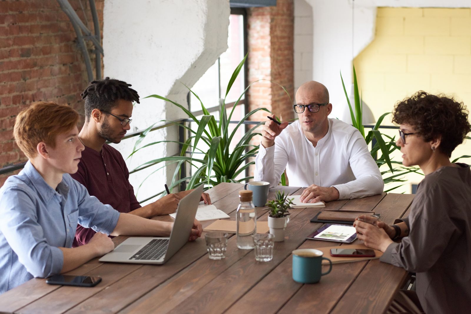 Small business owner and team discussing cybersecurity in a bright office